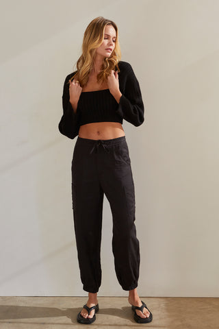 A model wearing a black stretchy knit bolero set.