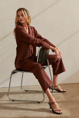 A model wearing a chocolate blazer set.