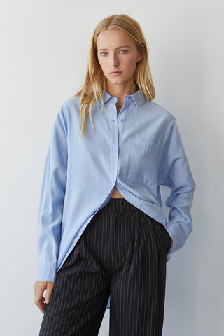 A model wearing a blue button up shirt.
