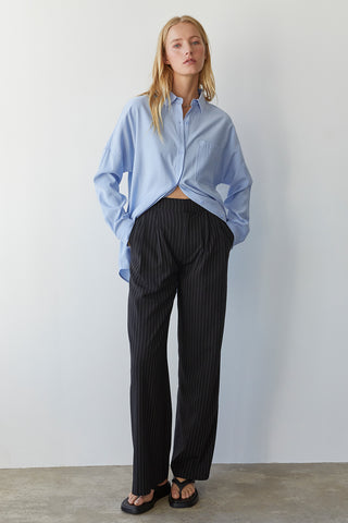 A model wearing a blue button up shirt.