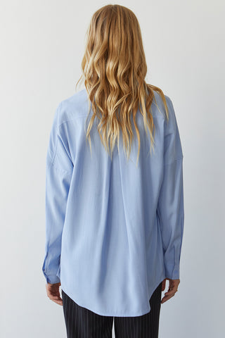A model wearing a blue button up shirt.
