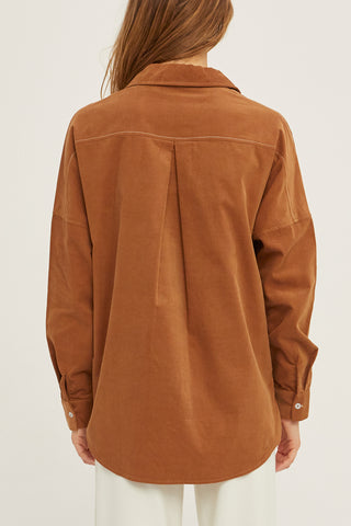A woman wearing a camel corduroy oversized shirt.