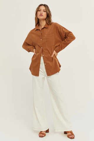 A woman wearing a camel corduroy oversized shirt.