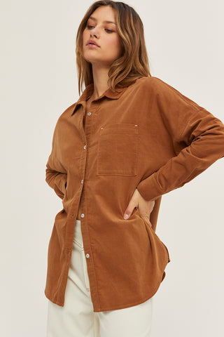 A woman wearing a camel corduroy oversized shirt.