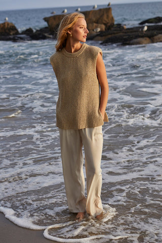 A model wearing a beige power shoulder sleeveless knit top.