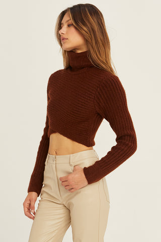 A model wearing a chocolate criss-cross crop turtle neck sweater.