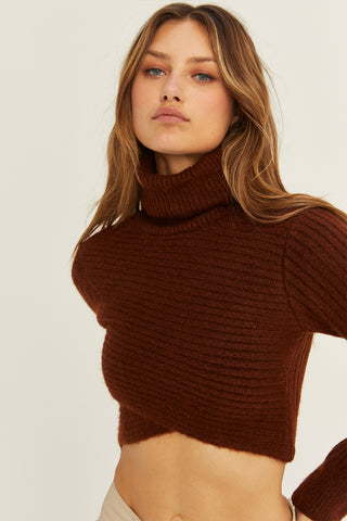 A model wearing a chocolate criss-cross crop turtle neck sweater.