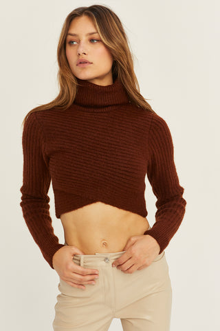 A model wearing a chocolate criss-cross crop turtle neck sweater.