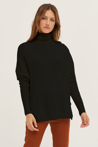 A model wearing a black dolman sleeve sweater.