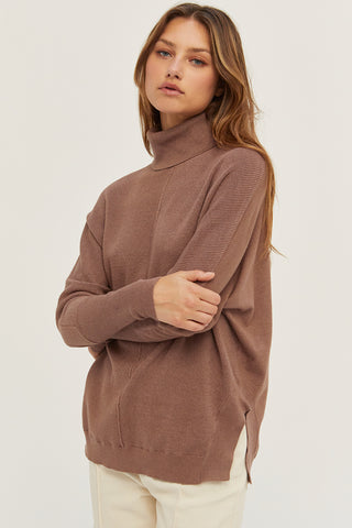A model wearing a mocha dolman sleeve sweater.