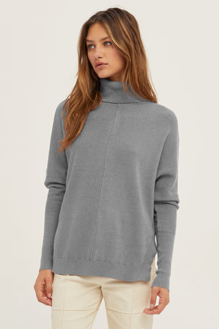 A model wearing a heather grey dolman sleeve sweater.