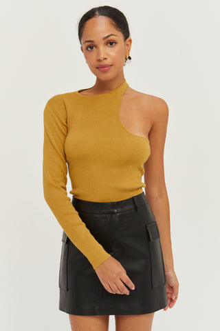 A woman wearing a marigold one shoulder cut out sweater top.