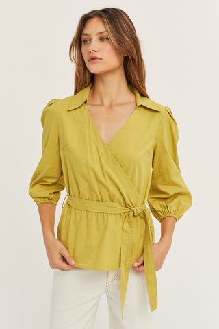 A woman wearing a fern tencel wrap top.