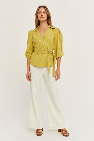 A woman wearing a fern tencel wrap top.