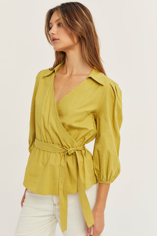 A woman wearing a fern tencel wrap top.