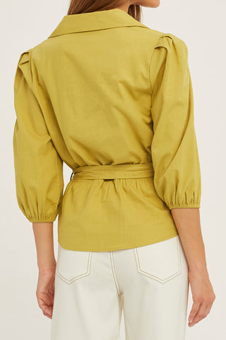 A woman wearing a fern tencel wrap top.