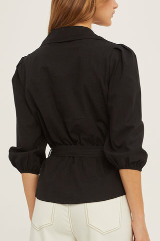 A woman wearing a black tencel wrap top.