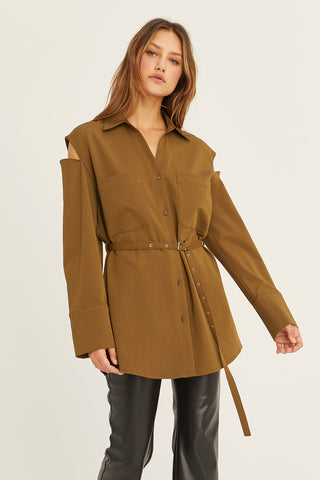 A model wearing a coffee cut out sleeve tunic top with micro belt on waist.