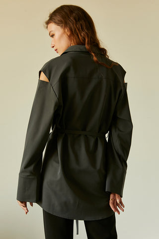 A model wearing a slate cut out sleeve tunic top with micro belt on waist.