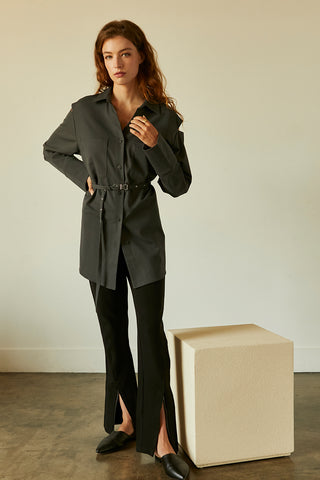 A model wearing a slate cut out sleeve tunic top with micro belt on waist.