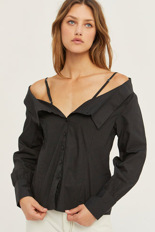 A woman wearing a black off the shoulder poplin blouse.