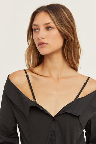 A woman wearing a black off the shoulder poplin blouse.