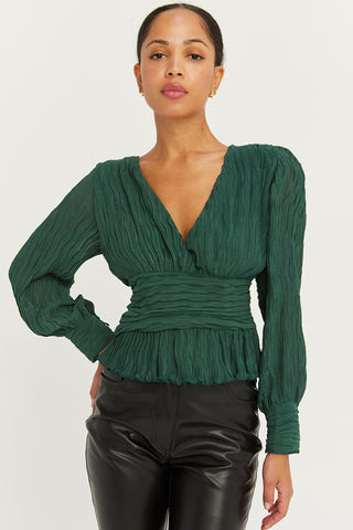 A model wearing a hunter green crinkled blouse.