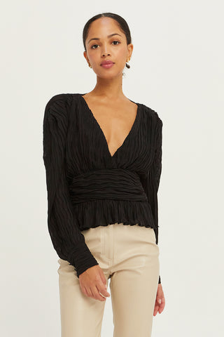 A model wearing a black crinkled blouse.