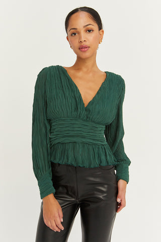 A model wearing a hunter green crinkled blouse.