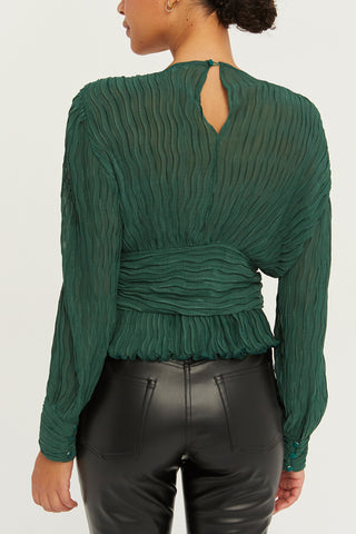 A model wearing a hunter green crinkled blouse.