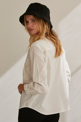 A model wearing a white button up utility blouse.