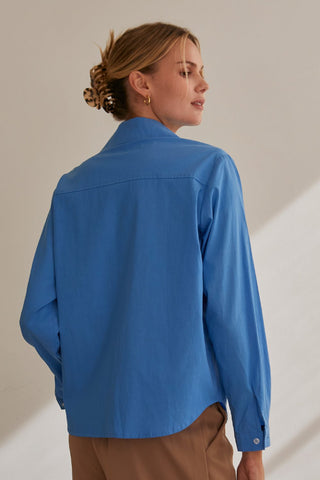 A model wearing a blue button up utility blouse.