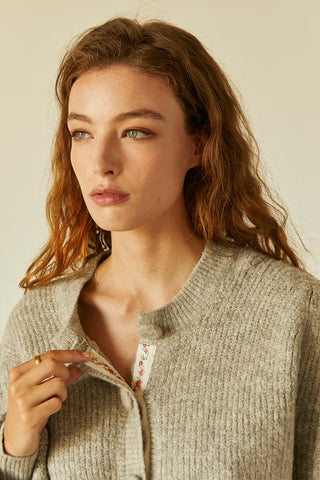 A model wearing a heather grey jacquard trim cardigan.