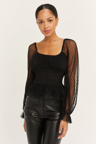 A model wearing a black pleated tulle smocked top.
