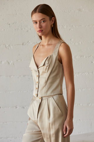 A model wearing a champagne sleeveless satin top with matching satin pants.