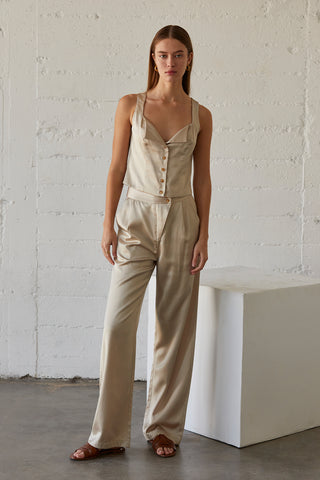 A model wearing a champagne sleeveless satin top with matching satin pants.