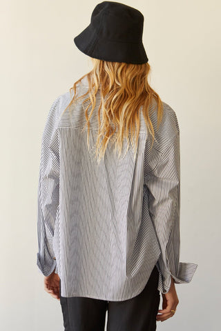 A model wearing a black pinstripe shirt.