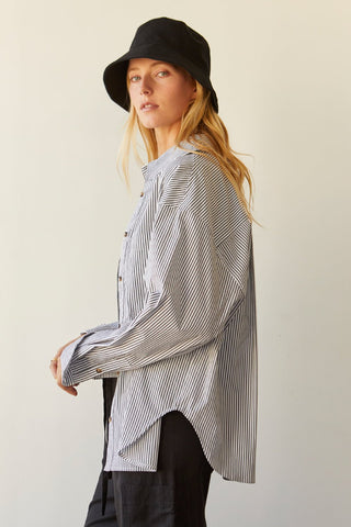 A model wearing a black pinstripe shirt.