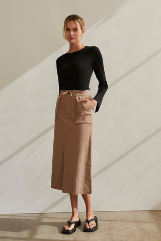 A model wearing a black long sleeve knit top with slit detail on sleeve.