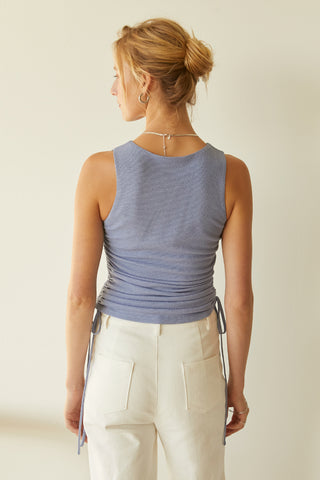 A model wearing a light blue ruched top.