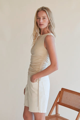 A model wearing an oatmeal ruched top.