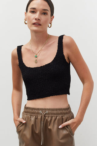 A woman wearing a black knitted tank top.