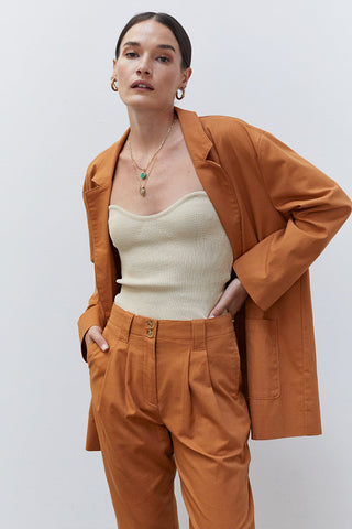 A woman wearing a beige rib corset top.