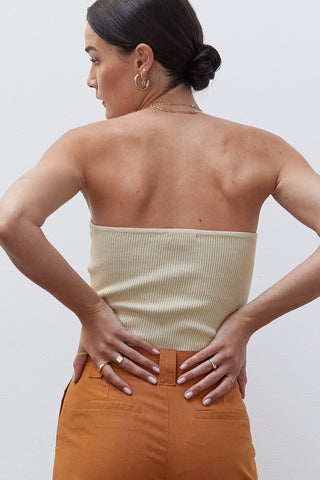 A woman wearing a beige rib corset top.