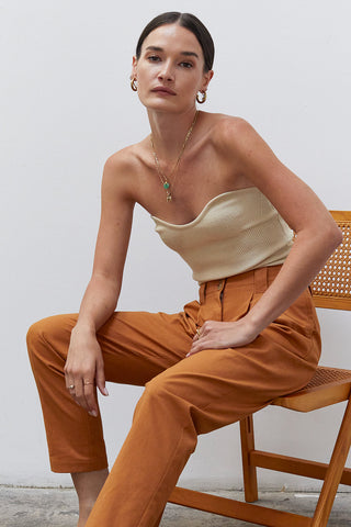 A woman wearing a beige rib corset top.