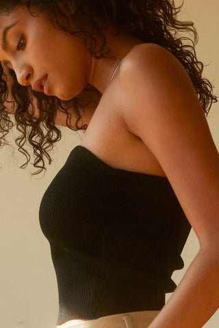 A woman wearing a black rib corset top.