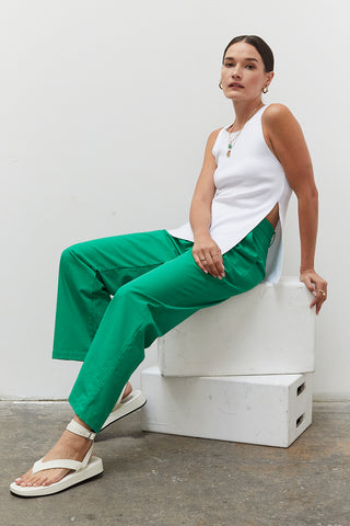 A woman wearing an emerald straight leg trousers.