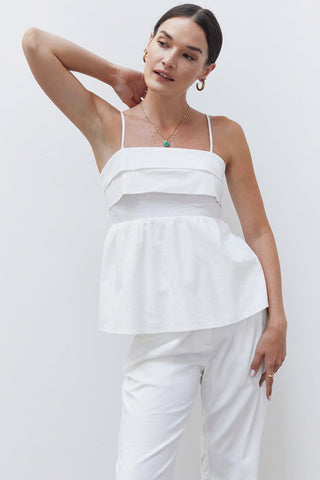 A woman wearing a white pleated babydoll camisole set.