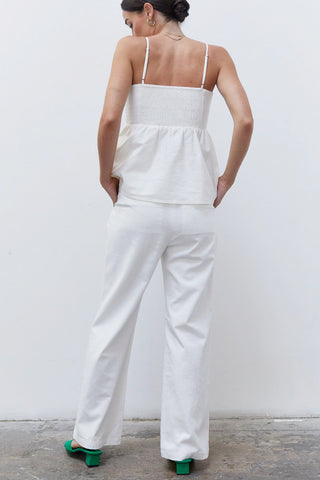 A woman wearing a white pleated babydoll camisole set.