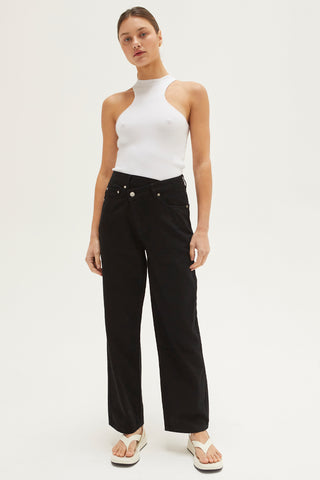 A woman wearing a black straight-leg asymmetric waist jean.